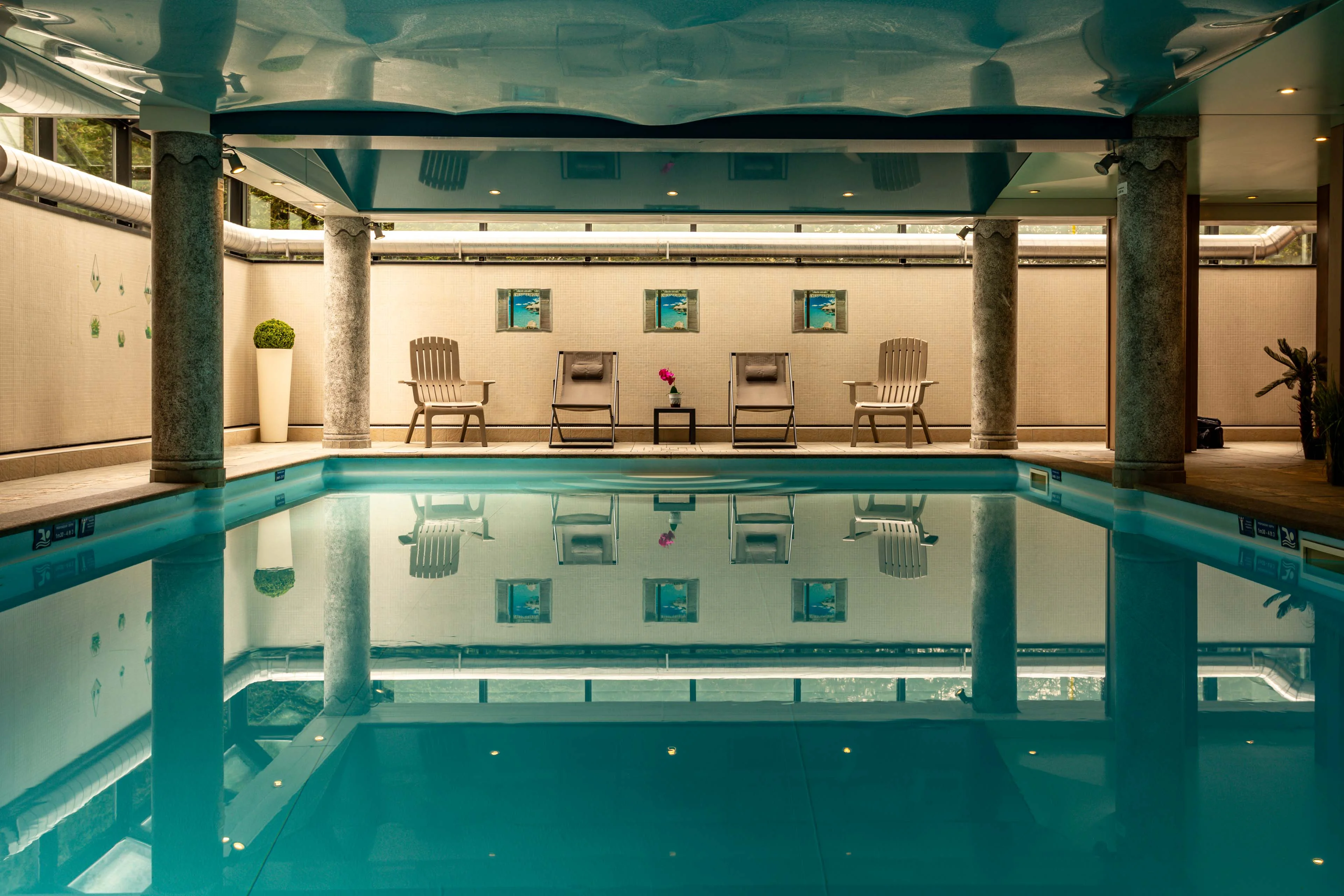 Piscine intérieure avec transats et colonnes en pierre à Chamonix