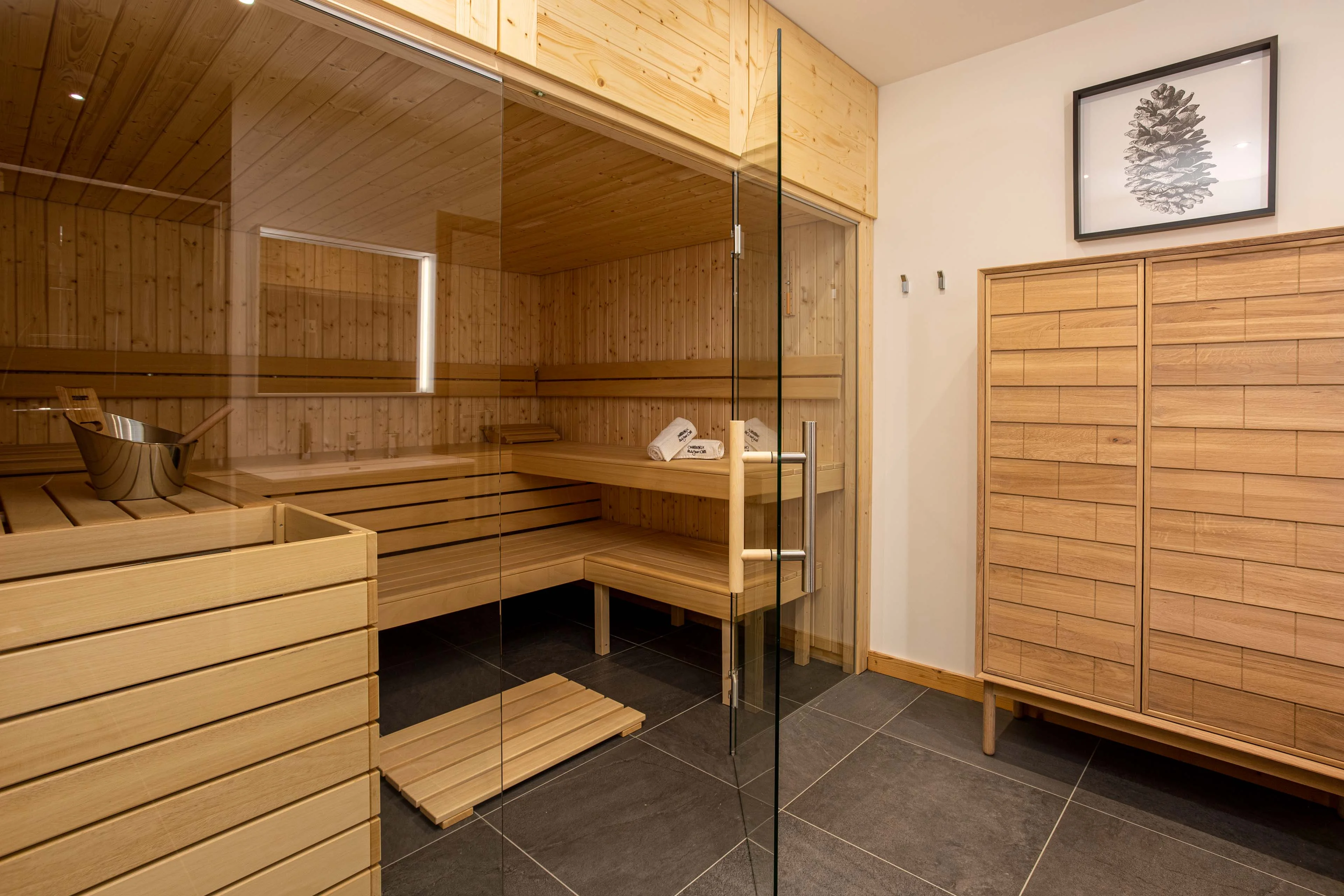 Sauna à façade vitrée avec serviettes disposées dans un chalet à Chamonix