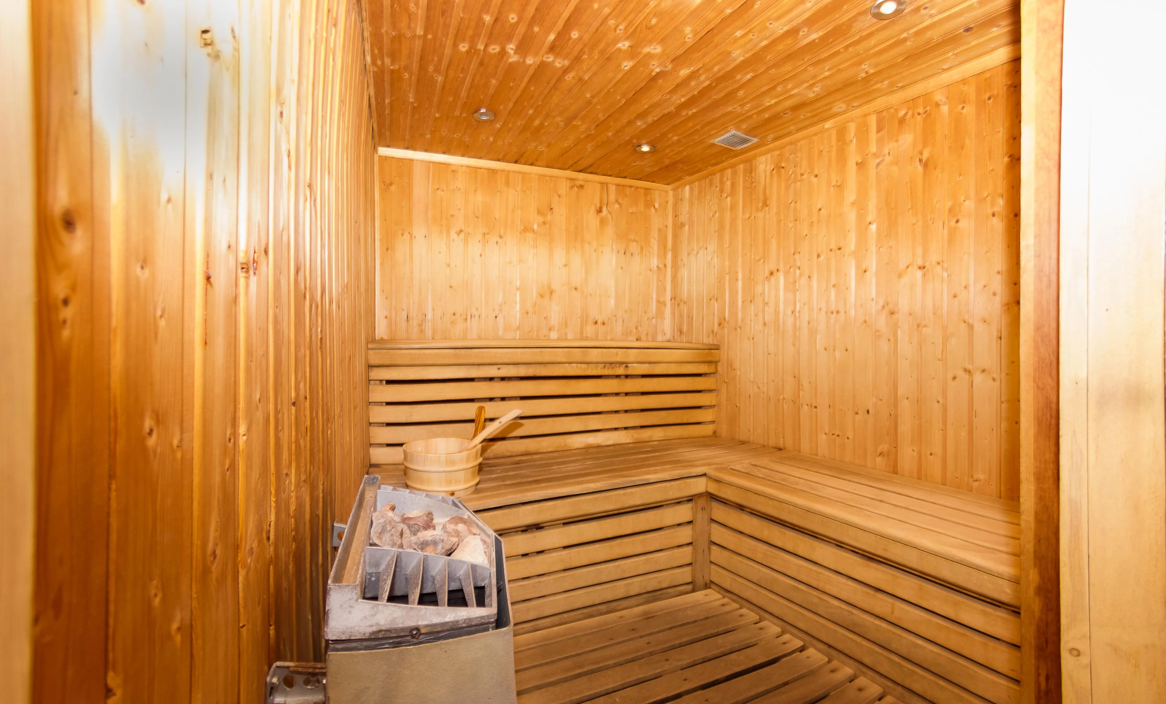 Petit sauna lambrissé avec poêle à pierres dans un appartement à Chamonix