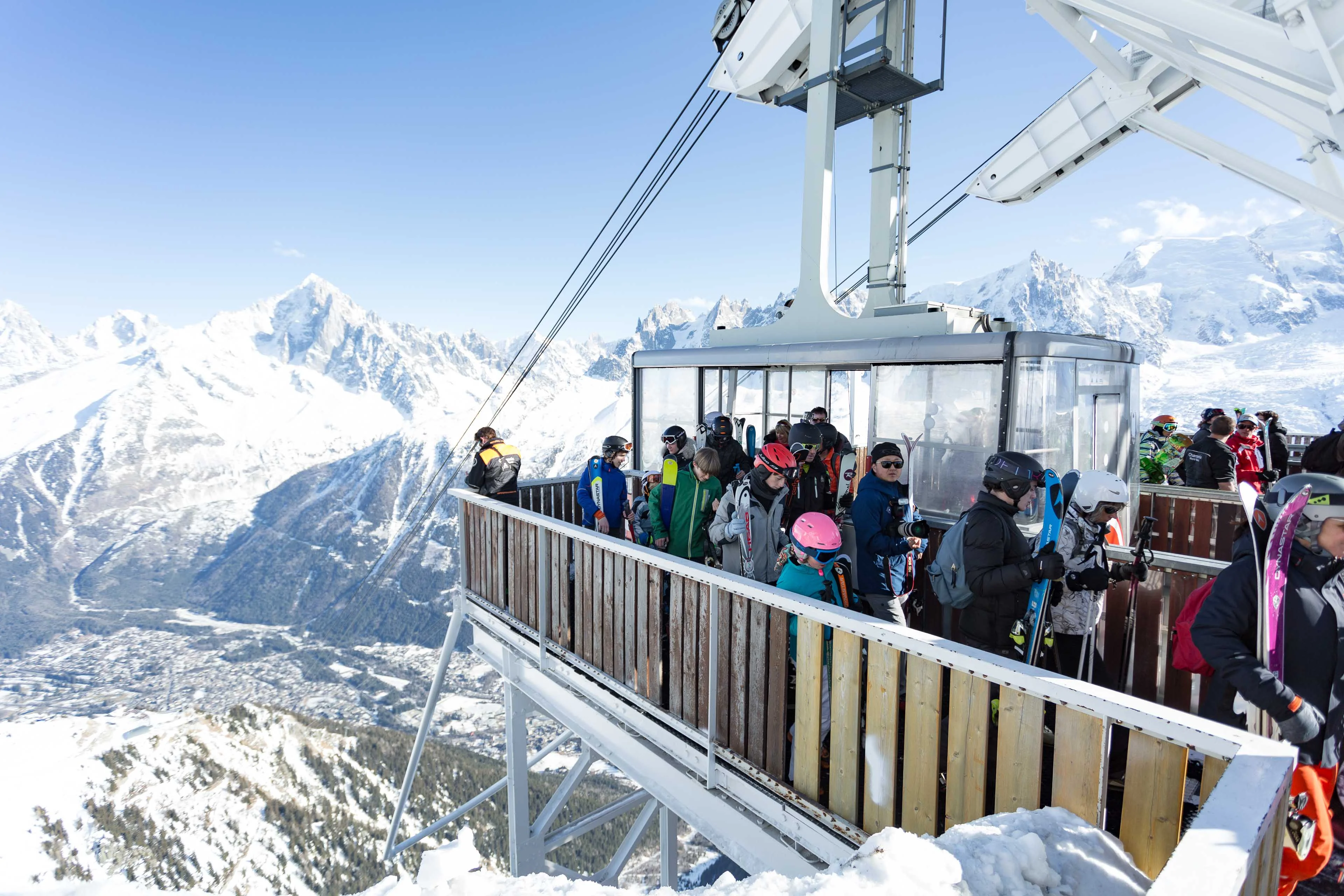 Skieurs embarquant dans le téléphérique du Brévent au-dessus de Chamonix, avec le massif du Mont Blanc en arrière plan