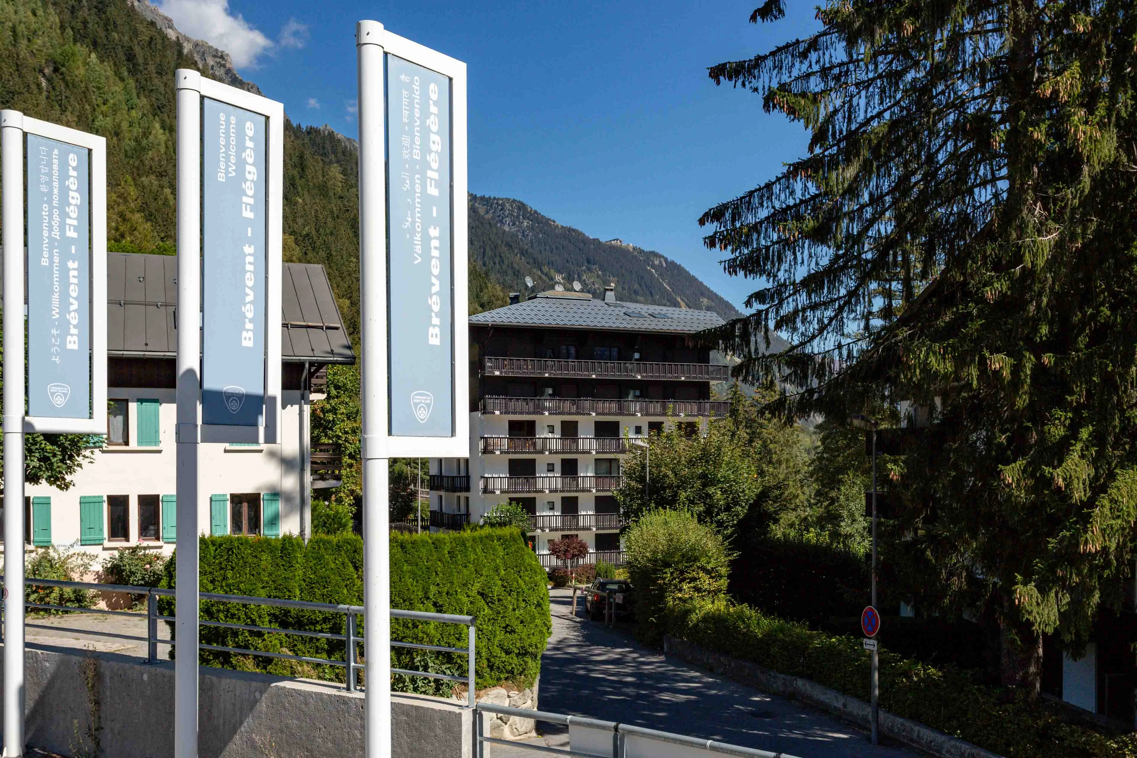 Panneaux d'accueil Brévent Flégère au départ des remontées à Chamonix, avec des immeubles d'habitation en arrière plan