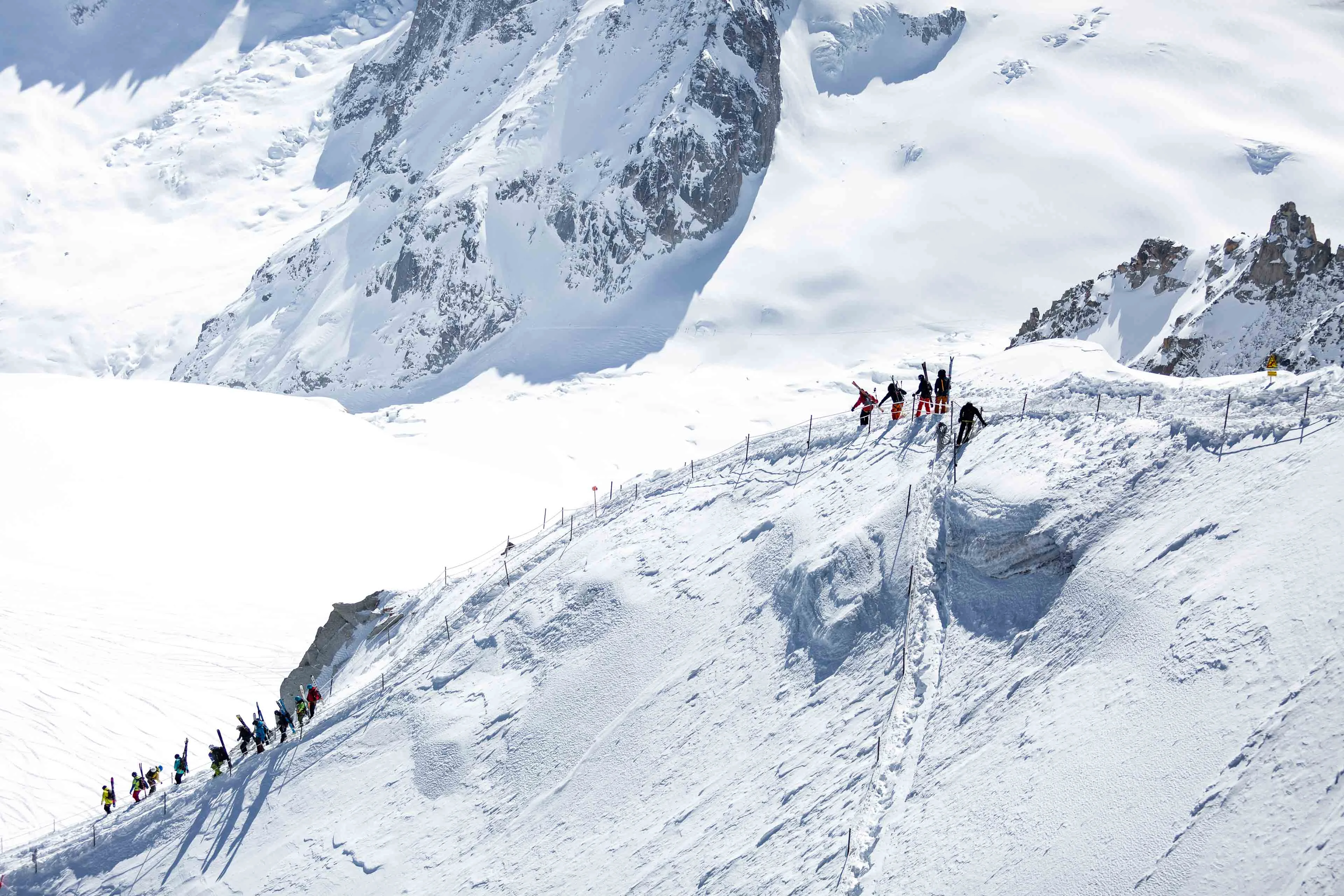 Skiers descending the Aiguille du Midi arête above the Vallée Blanche in Chamonix