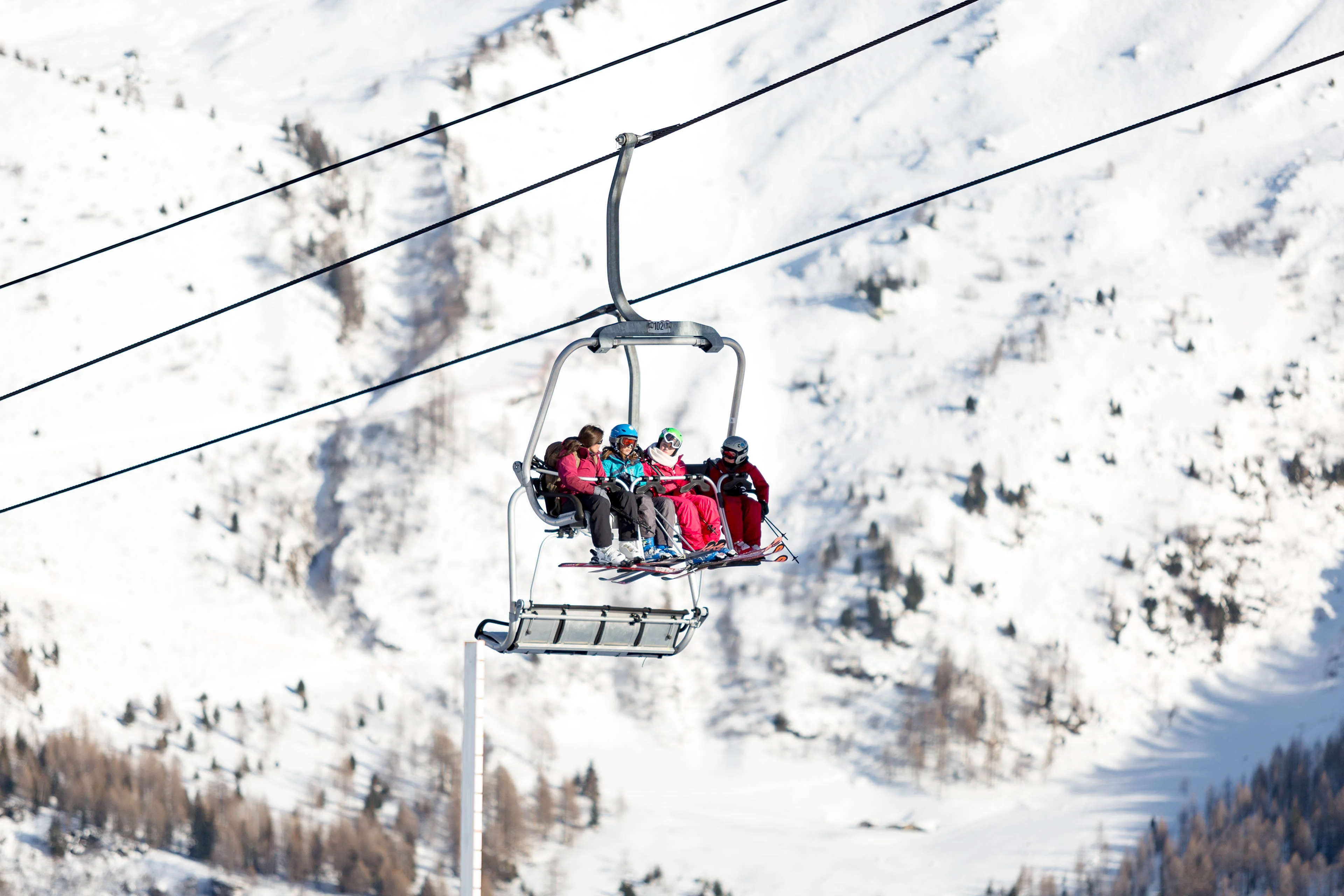 Quatre skieurs sur un télésiège au-dessus d'une pente enneigée à Chamonix