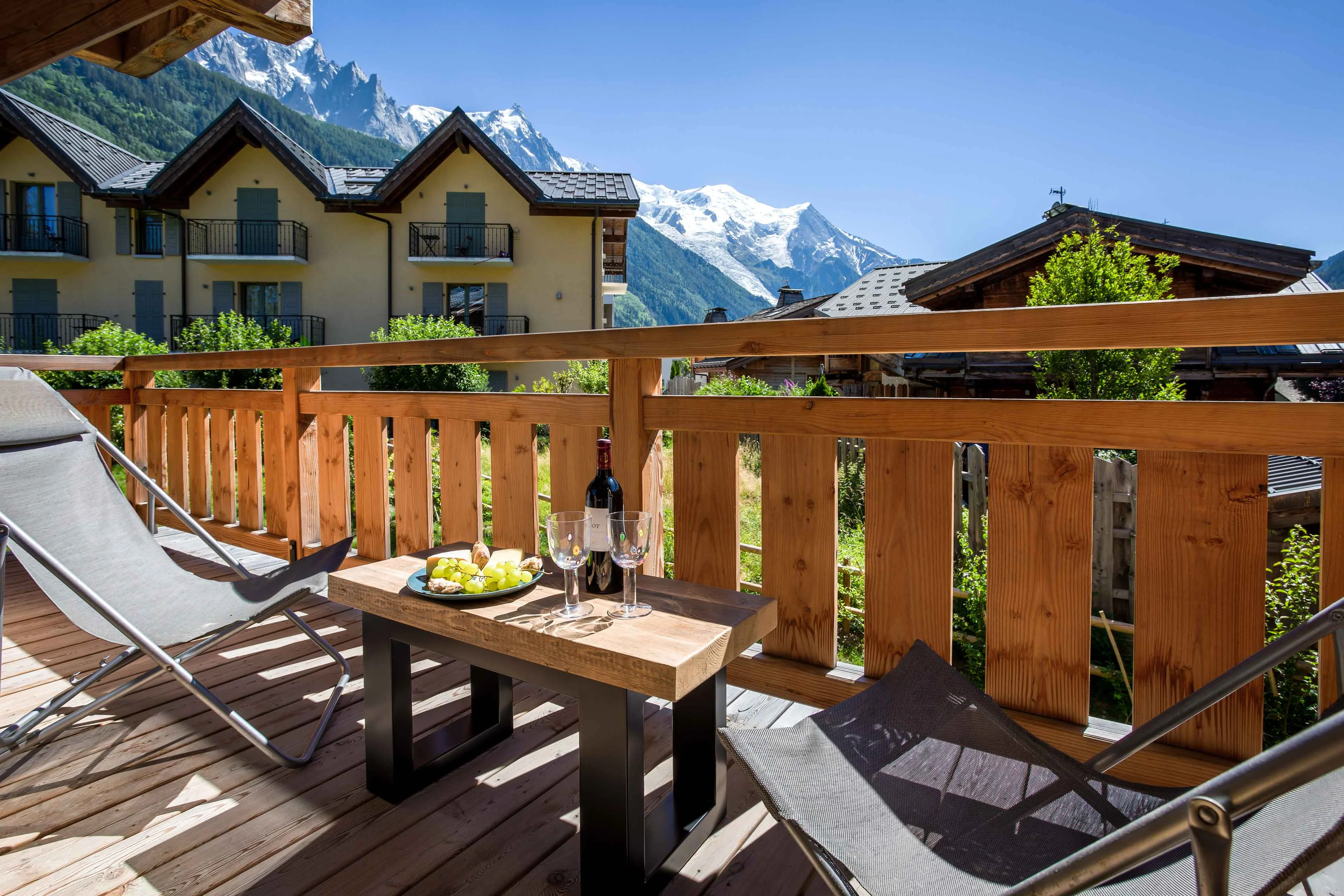 Balcon en bois avec transats et petite table à Chamonix, face au Mont Blanc