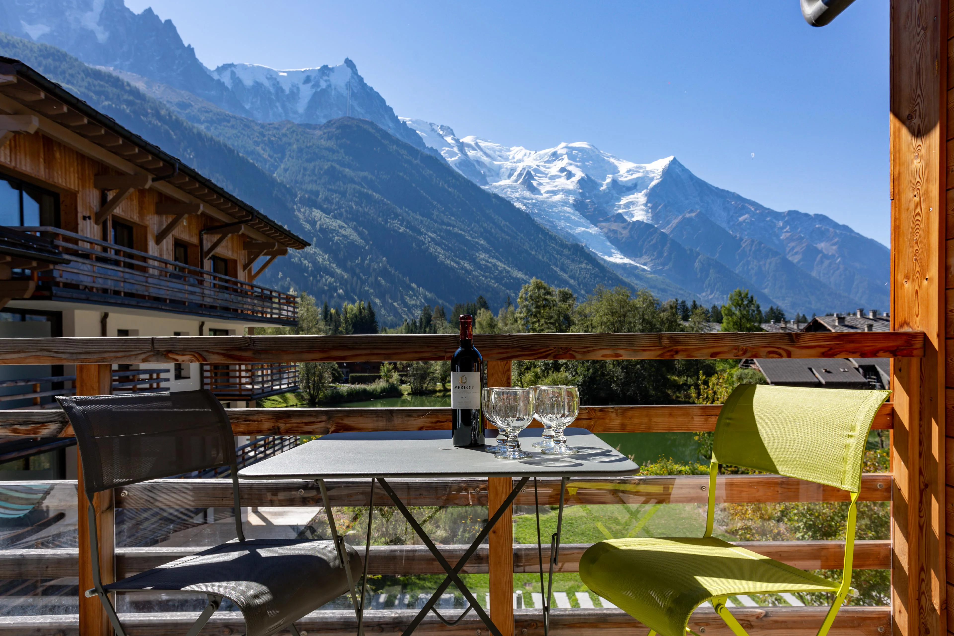 Table et chaises sur le balcon d'un appartement à Chamonix, avec l'Aiguille du Midi et le Mont Blanc en arrière plan