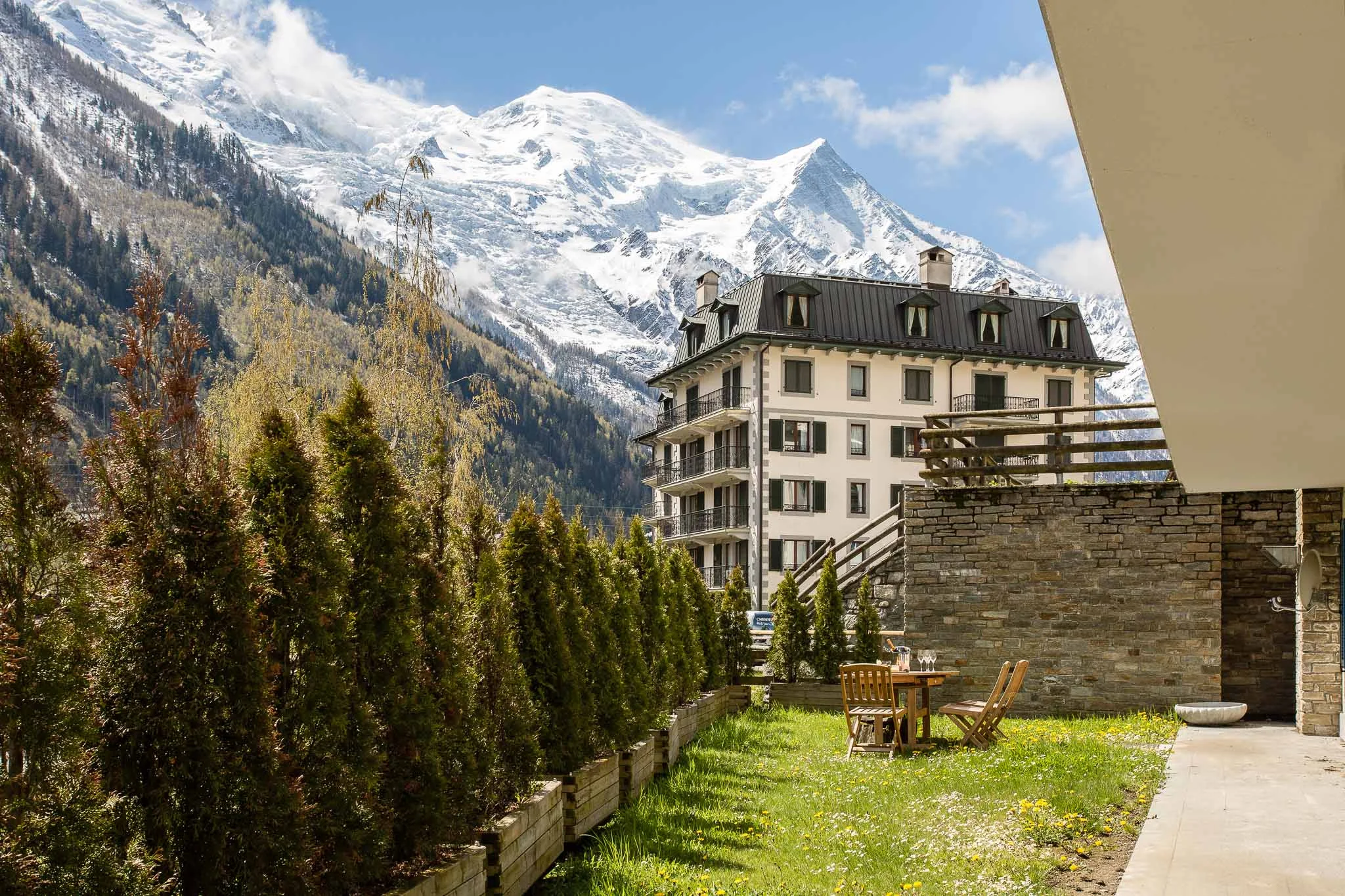 Jardin d'appartement à Chamonix avec table pour deux au pied du massif du Mont Blanc enneigé
