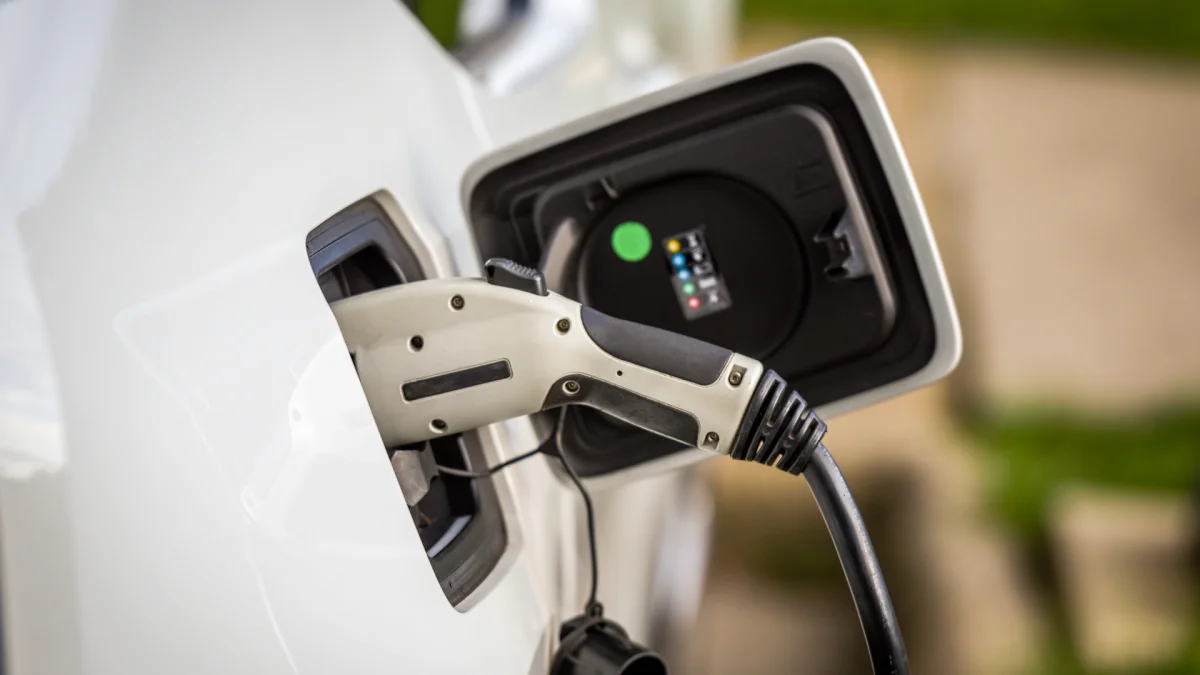 Câble de recharge branché sur une voiture électrique blanche