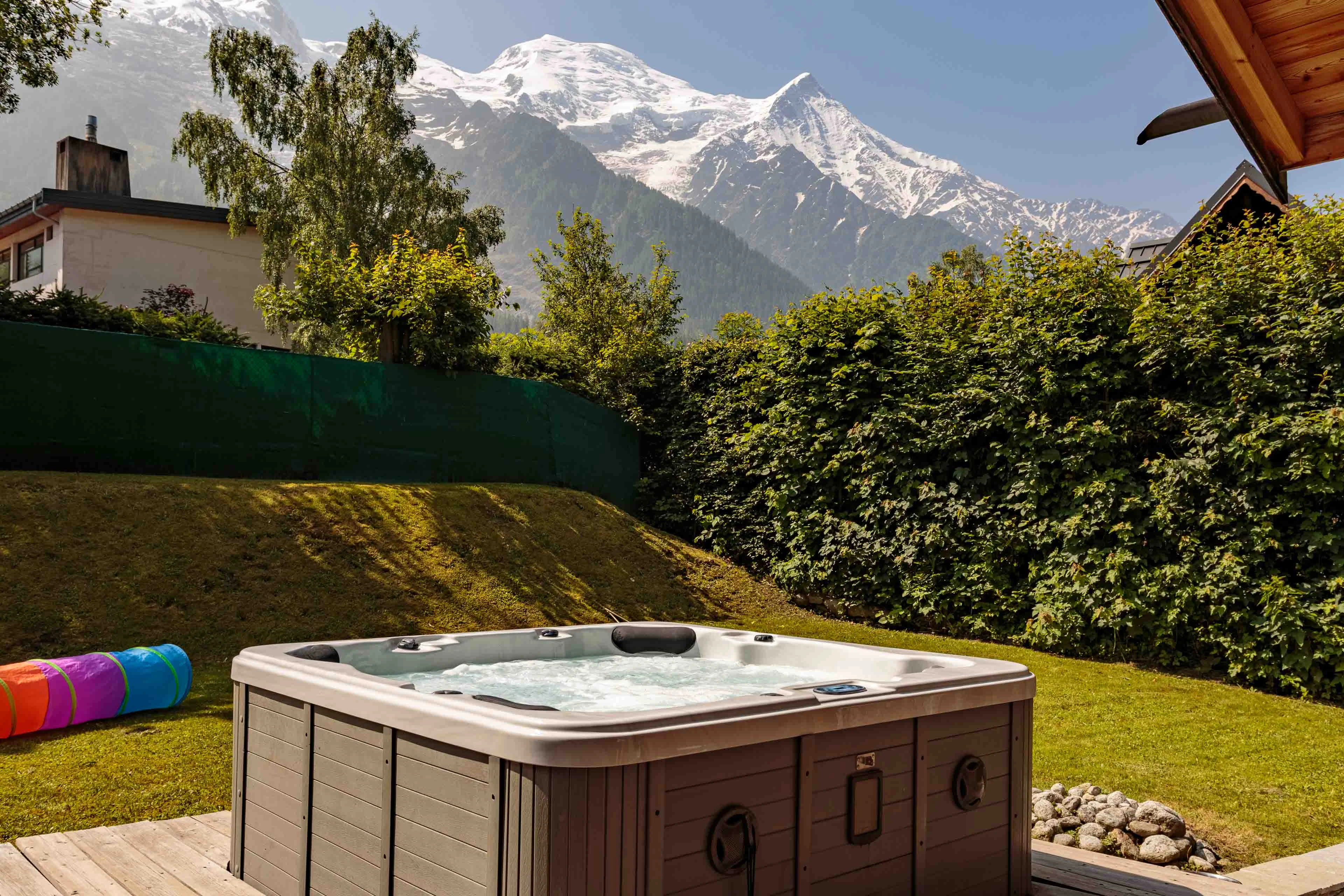 Hot tub in the garden of a Chamonix chalet in summer, facing Mont Blanc and the Aiguille du Goûter