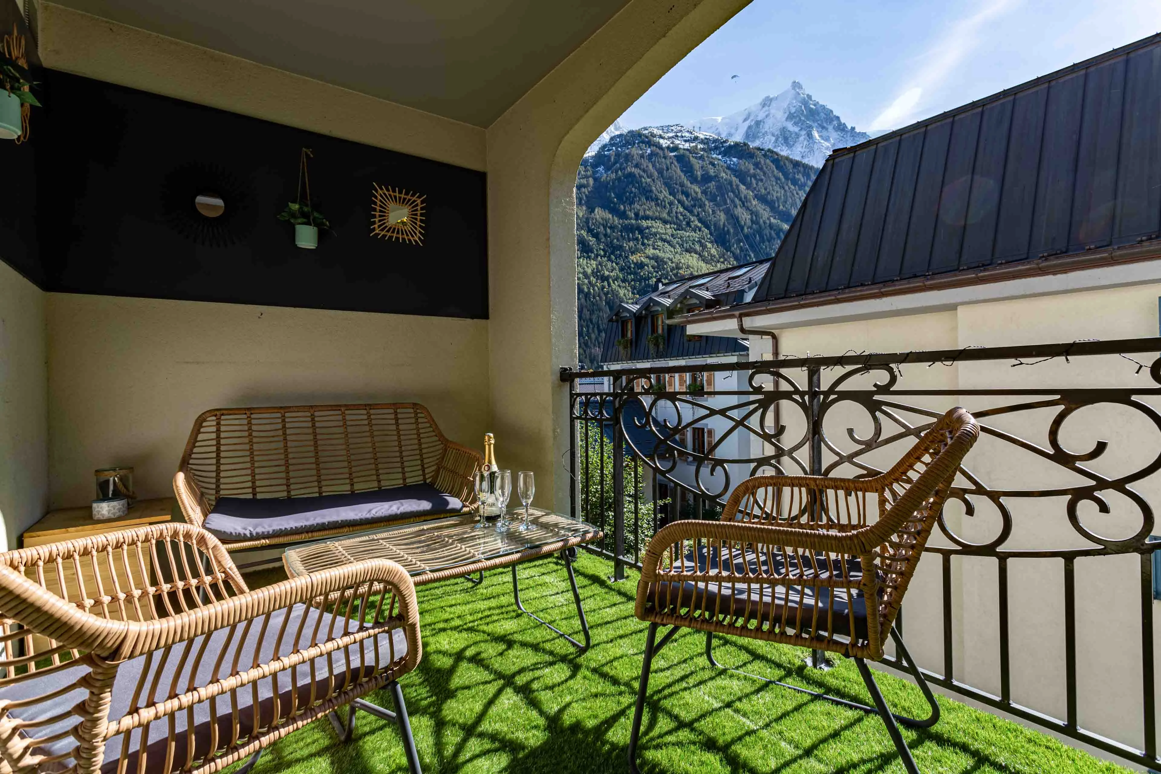 Covered apartment balcony in Chamonix with rattan seating, looking out to the Aiguille du Midi