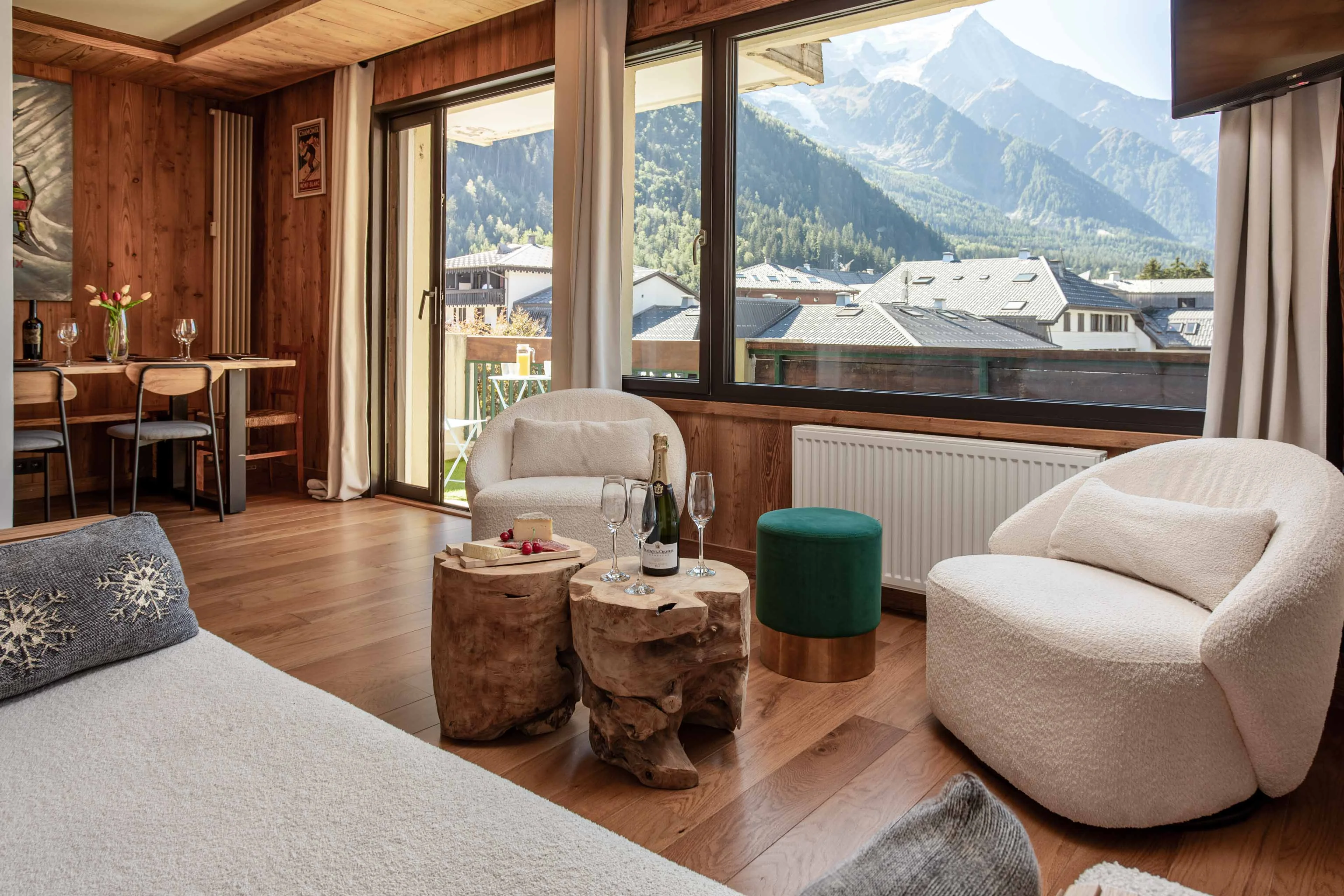 Living room in a Chamonix apartment with timber walls and a picture window onto Mont Blanc