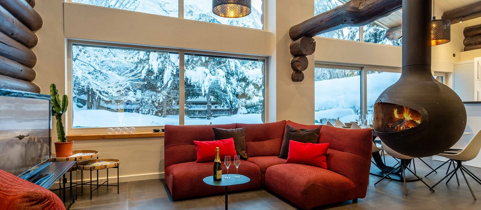 Poêle à bois suspendu et table à manger dans un chalet en rondins à Chamonix
