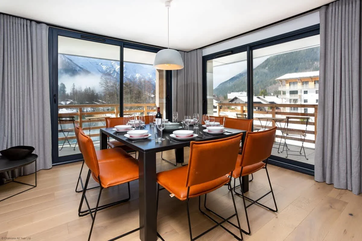 Floor to ceiling windows with dining table seating 8